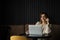 Beautiful caucasian woman concentrated while using laptop in a modern workspace. Cute young business woman speaking on the phone