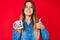 Beautiful caucasian woman drinking from i am the boss coffee cup smiling happy and positive, thumb up doing excellent and approval