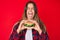 Beautiful caucasian woman eating a tasty classic burger sticking tongue out happy with funny expression