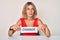 Beautiful caucasian woman holding change banner smiling looking to the side and staring away thinking