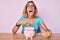 Beautiful caucasian woman holding piggy bank with glasses angry and mad screaming frustrated and furious, shouting with anger