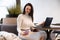 beautiful caucasian woman makes selfie on a smartphone sitting at a table with a laptop. a blogger creates content, a