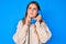 Beautiful caucasian woman speaking on vintage telephone serious face thinking about question with hand on chin, thoughtful about