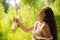 Beautiful caucasian woman sprays herself with water for freshness on a hot summer day.