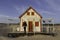 Beautiful caucasian woman wearing a black leather jacket under the porch of a typical abandoned house on the beach at Costa da