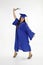 Beautiful Caucasian woman wearing a blue graduation gown holding diploma