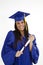 Beautiful Caucasian woman wearing a blue graduation gown holding diploma