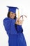 Beautiful Caucasian woman wearing a blue graduation gown holding diploma