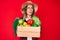 Beautiful caucasian woman wearing farmer hat holding vegetables angry and mad screaming frustrated and furious, shouting with