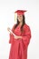 Beautiful Caucasian woman wearing a red graduation gown holding diploma