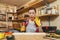 Beautiful caucasian young woman working in carpentry workshop at table place