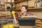 Beautiful caucasian young woman working in carpentry workshop at table place