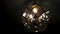Beautiful chandelier in the loft hanging from the ceiling on a dark background.