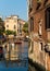 Beautiful charming facade with sculpture and bridge over a canal in Venice, Italy