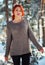 Beautiful charming girl with red hair in the winter park. Pensive, dreamy, loving look. Cold weather. Trees in the snow