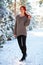 Beautiful charming girl with red hair in the winter park. Pensive, dreamy, loving look. Cold weather. Trees in the snow