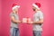 beautiful cheerful couple in santa hats gifting christmas present, isolated