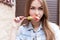 Beautiful cheerful cute red-haired girl eating colored ice cream on city streets