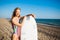 Beautiful cheerful surfer girl on the beach at sunset.