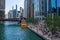 Beautiful Chicago River scene where water taxi stops at riverwalk where stairs full of people are resting on lunch breaks