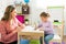 Beautiful child coloring a book with the help of a tutor at home