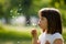 Beautiful child with dandelion flower in spring park. Happy kid having fun outdoors.