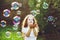 Beautiful child enjoying blowing soap bubbles