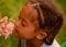 Beautiful child smelling flower