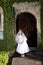 Beautiful child in white dress outside chapel door