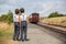 Beautiful children, dressed in vintage clothes, enjoying old steam train on a hot summer day