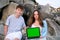 beautiful children girl and boy teenagers sitting on stones with laptop in hands green screen ad light clothes