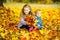 beautiful children play with autumn fallen leaves
