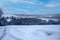 Beautiful chilling view of a fir forest near a village during winter