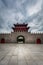 Beautiful Chinese asian architecture with stone wall and entrance at a square with red dragon building.