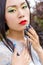 Beautiful Chinese girl in kimono with long false nails near the face with red lipstick