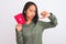 Beautiful chinese woman holding Japan Japanese passport over isolated white background with angry face, negative sign showing