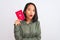 Beautiful chinese woman holding Japan Japanese passport over isolated white background scared in shock with a surprise face,