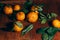 Beautiful Christmas decoration with tangerines in the night light garlands. Citrus still life. The symbol of the new year