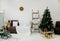 Beautiful Christmas interior. A Christmas tree decorated with toys for the new year. Soft sofa, plaid