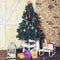 Beautiful Christmas interior design. Home decorated with Christmas tree with gift under the tree, sled and small lamp, toned