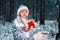 Beautiful Christmas portrait of the Snow Maiden. little girl alone in a cold forest with gifts