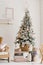 A beautiful Christmas tree with artificial snow stands in the living room in beige colors