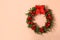 Beautiful Christmas wreath with festive decor on coral wall, space for text