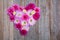 Beautiful chrysanthemum flowers in the shape of a heart on a wooden table
