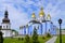 A beautiful church with glistening gold domes and high crosses on their top looking to the sky located on a landscaped