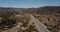 Beautiful cinematic aerial shot, car and camper van driving on sunny desert hill road in USA. Road trip travel adventure