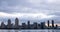 Beautiful city scape with water bay and clouds moving across the dark sky and above the modern architecture buildings