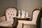 Beautiful classic interior, two armchairs and a coffee table with a candle decor in the form of chess. White chess candles