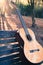 Beautiful classical guitar on a bench in the park with lens flare. Photo of a new wooden guitar with nylon strings outdoors in the