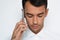 Beautiful close-up portrait of young man using mobile phone on gray background.